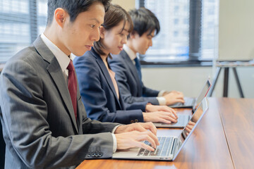 ノートパソコンで仕事をする３人の男女のビジネスマン