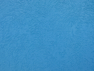 Blue plastered wall with bark beetle type surface.