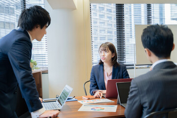 ノートパソコンで会議をする３人の男女のビジネスマン