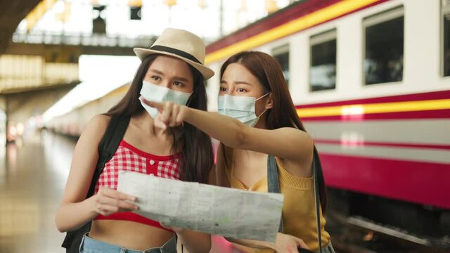 Woman traveler with bag, luggage, arrival   during traveling, travel, trip for woman concept, say hi, good bye to friend.trip in summer with face mask for protection by infection from Coronavirus.