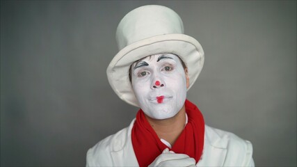 Very cute pantomime close up. Closeup portrait of a cute guy. A handsome guy mime smiles.