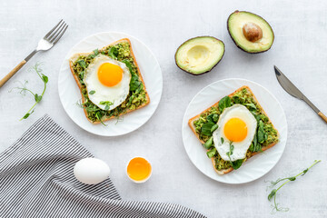 Open sandwich with eggs and avocado on plate. Overhead view