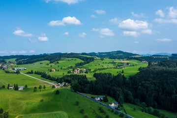 Fototapeta na wymiar Panorama aerial view of the green Swiss hills on a summers day with blue skies.