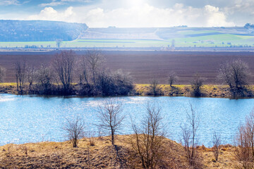 Spring landscape with river and field on a sunny day