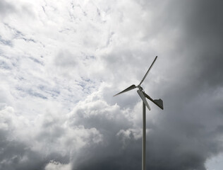 The small wind turbine under the cloudy sky in the countryside farm.