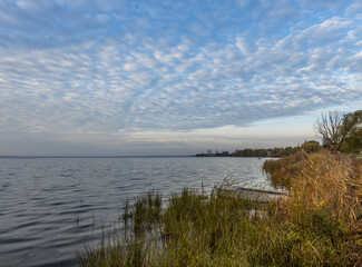 Colorful sunrise on the shores of Lake Nero. Autumn landscape with a lake in the early morning. A bright streak of light on the horizon, dawn.