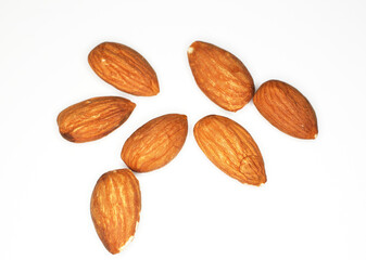 Group of unshelled almonds arranged on light background. 