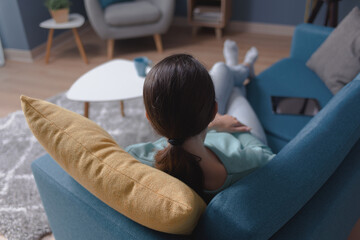 Woman relaxing on the sofa at home - obrazy, fototapety, plakaty