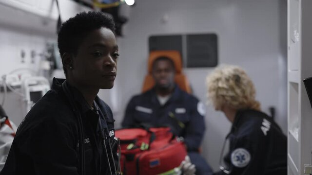 African american paramedic feeling worried while riding to accident
