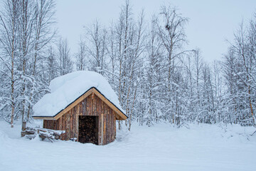 Kleine Holzhütte Schuppen zur Brennholz Lagerung im Schnee in Finnland Lappland Muonio