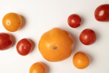 Healthy food composition of various fresh yellow and red tomato isolated on a white background. Top view, banner.