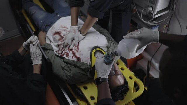 Multicultural paramedics rescuing man in ambulance car