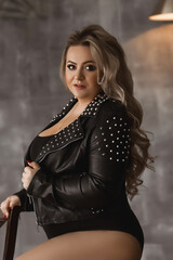 Plus-size woman with long blond hair in a leather jacket, overweight blonde with lush forms in the...