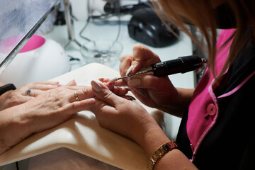 Obraz na płótnie Canvas Professional manicurist fixes and beautifies a client's nails
