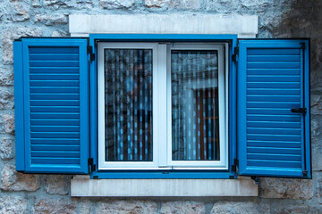 Fototapeta premium Modern plastic shutters on the old building, preservation of the style of architecture with new technologies.