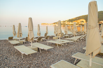Fototapeta premium Empty sunbeds on the beach, the beginning of the tourist season, waiting for vacationers during quarantine.