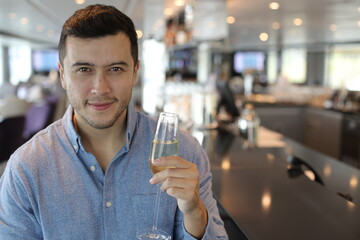 Handsome young man drinking champagne at bar 