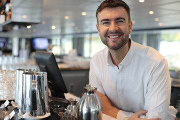 Male server smiling behind the counter