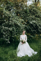 Obraz na płótnie Canvas bride with a wedding bouquet in the forest