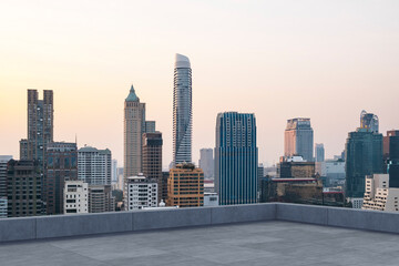 Fototapeta premium Panoramic Bangkok skyline view, concrete observatory deck on rooftop, sunset. Luxury Asian corporate and residential lifestyle. Financial city downtown, real estate. Product display mockup empty roof