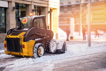Excavator city service cleaning snow winter tractor after snowstorm yard sunlight