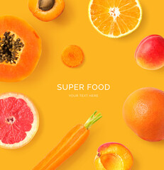 Creative layout made of  papaya, orange, carrot, grapefruit and apricot on the orange background. Flat lay. Food concept. Macro  concept.