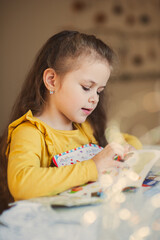 Cute little girl writes a letter to Santa Claus. Christmas concept