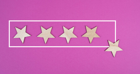Five stars on a pink colored background, hand put the last star in the row, rating, giving feedback