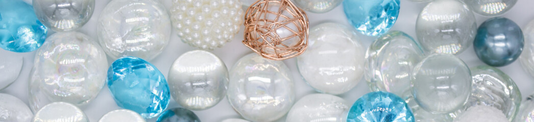 Banner with beautiful background of transparent, blue glass beads, crystals, white pearls. Copy space