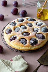 Plum pie on a pink background. Baking. Vegetarian food.