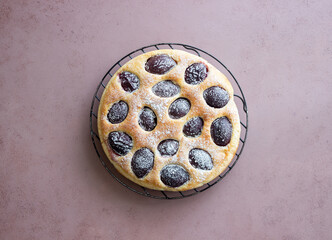 Plum pie on a pink background. Baking. Vegetarian food.