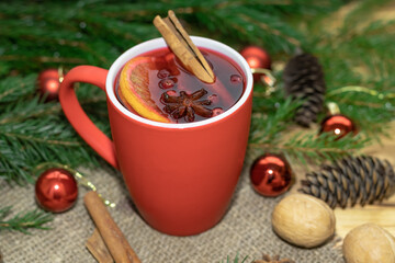 Christmas drink mulled wine in red mug,concept holiday Christmas,cinnamon orange tree cones