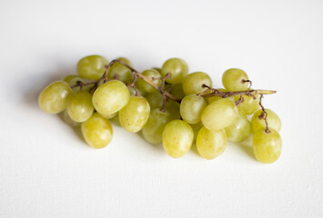 Stem of green grapes on a white background