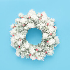 White christmas wreath with decoration on a light blue background. Flat lay