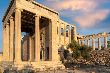 Erechtheion Temple (Erechtheum) with the Caryatids at the archaeological site of Acropolis in Athens, Greece. Parthenon Temple in the background. Angled front view, colorful clouds, blue sky