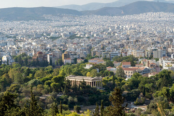 Athens, Greece. Panoramic view of the ancient greek Temple of Hephaestus located at the Ancient Agora of Athens archaeological site in Thissio district as seen from the Acropolis. Sunny day, aerial