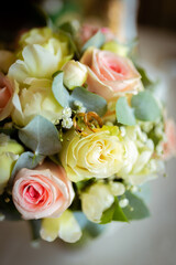 Wedding rings on a petal of a rose. Concept for a wedding card. The bride's bouquet. High quality photo