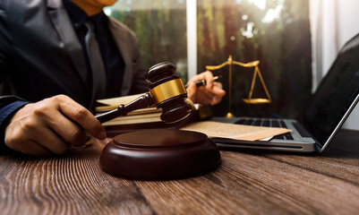 Justice and law concept.Male judge in a courtroom with the gavel, working with, computer and...