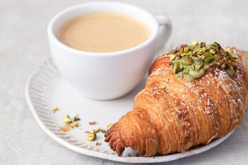 Cup of coffee and croissant on  table