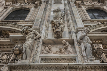 Fototapeta premium Architectural fragment of Milan Cathedral (Duomo di Milano, 1386), dedicated to St Mary of the Nativity (Santa Maria Nascente), with Gothic and Lombard Romanesque style. Milan, Italy.