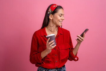 Naklejka premium hispanic beautiful woman in red shirt smiling holding smartphone