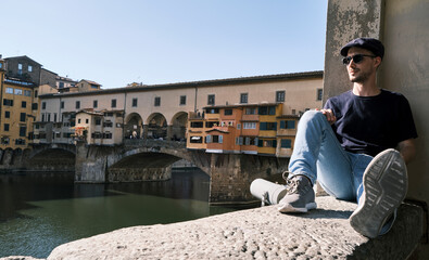 a man with sunglasses and a beret on the Ponte Vecchio