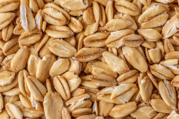 Fototapeta premium Rolled oat, oat flakes background or texture. Close up, directly above.Heap of dry rolled oats isolated.