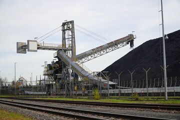 Fototapeta na wymiar Stone coal stockpile at the coal-fired power plant in Hanover, Lower Saxony, Germany. Old technology that is one of the factors causing global warming.