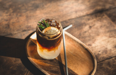 Top view of ice coffee with lemon and mix soda on wood rustic. A glass of americano mixed with...