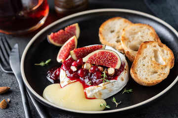 Baked camembert cheese with cranberry sauce, figs and bread toast