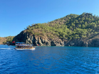 Beautiful tourist ship, cruise yacht on the background of the blue sea with water and mountains in a tropical southern country