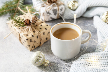 Obraz na płótnie Canvas Christmas composition with cup of coffee, knitted blanket, garland and gift on a gray background. Winter, Christmas concept.