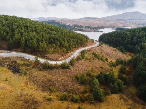 Aerial  view of curved mountain road and Ribnicko Lake or Ribnica lake  in mount Zlatibor, Serbia. Nature outdoors travel destination
