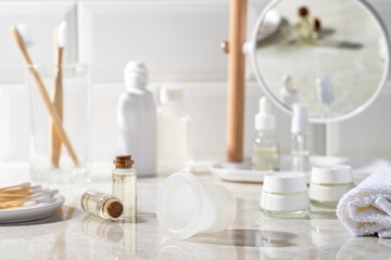 Fototapeta na wymiar Vacuum jar for massage in the bathroom. Mirror, massage oil, towel, cream, cotton swabs in the background.